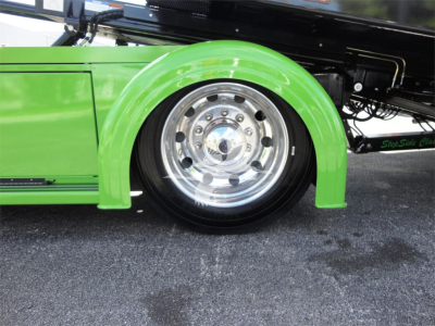 Green Peterbilt 337 rollback truck wheel with chrome rim and green fender.