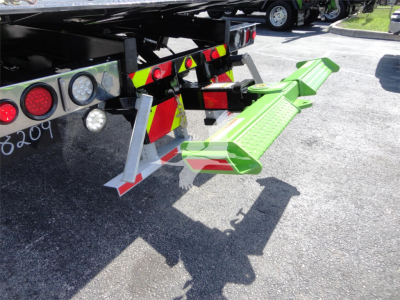 Peterbilt 337 rollback truck rear with green access steps and taillights visible.