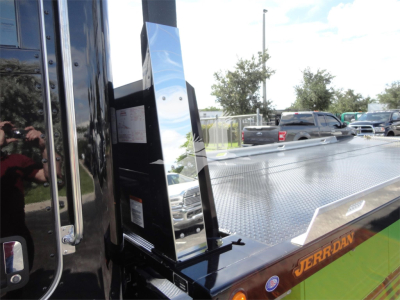 Peterbilt 337 rollback truck side view showing chrome step and diamond plate bed with 'JERR-DAN' logo on orange/green stripe.