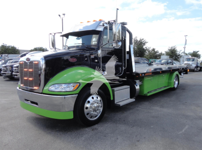 Peterbilt 337 rollback truck in black and bright green livery, front cab with chrome grille and large mirrors, side view showing green drop-deck, wheel wells, and chrome steps.