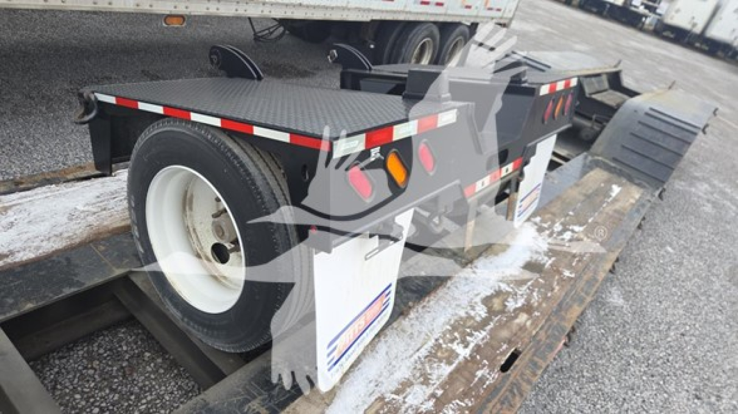 Pitts LB55-18DC lowboy trailer showing rear wheel and deck with white wheel rims and reflective tape