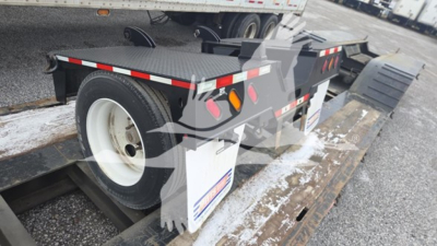 Pitts LB55-18DC lowboy trailer showing rear wheel and deck with white wheel rims and reflective tape