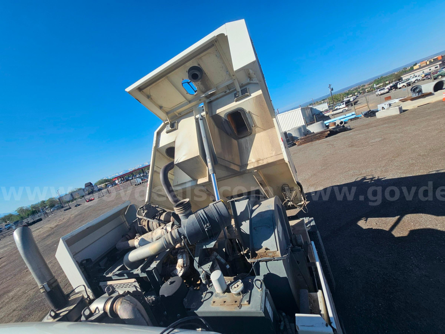 Truck engine bay of a 2016 Freightliner M2 106 sweeper showing exposed engine components and open hood.