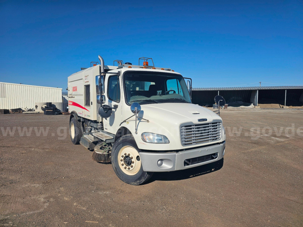 Freightliner M2 106 sweeper truck front-left view showing white body and side branding.