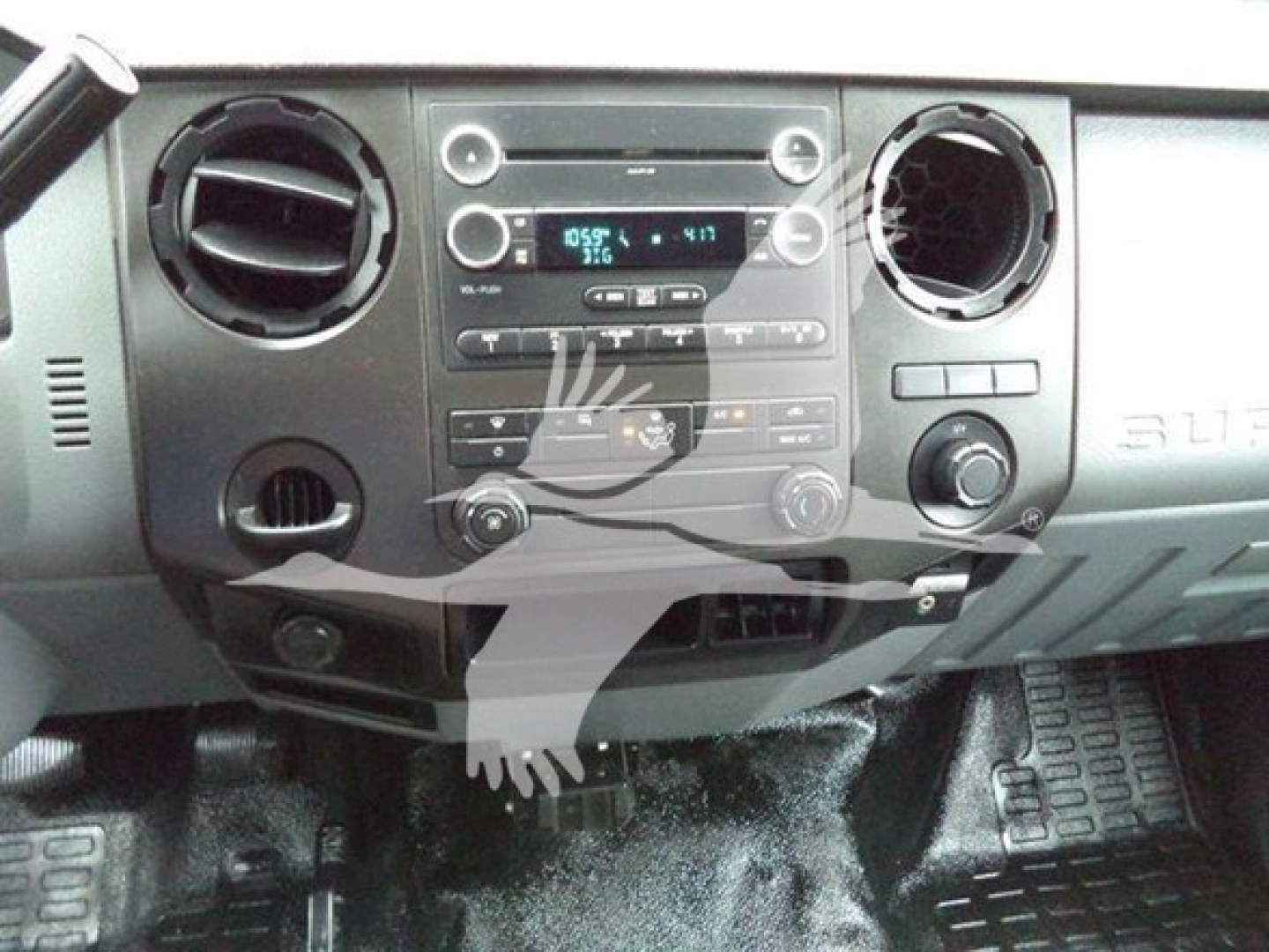 Ford F-650 dashboard view showing center console with radio/display, climate controls, circular air vents, and floor pedals.