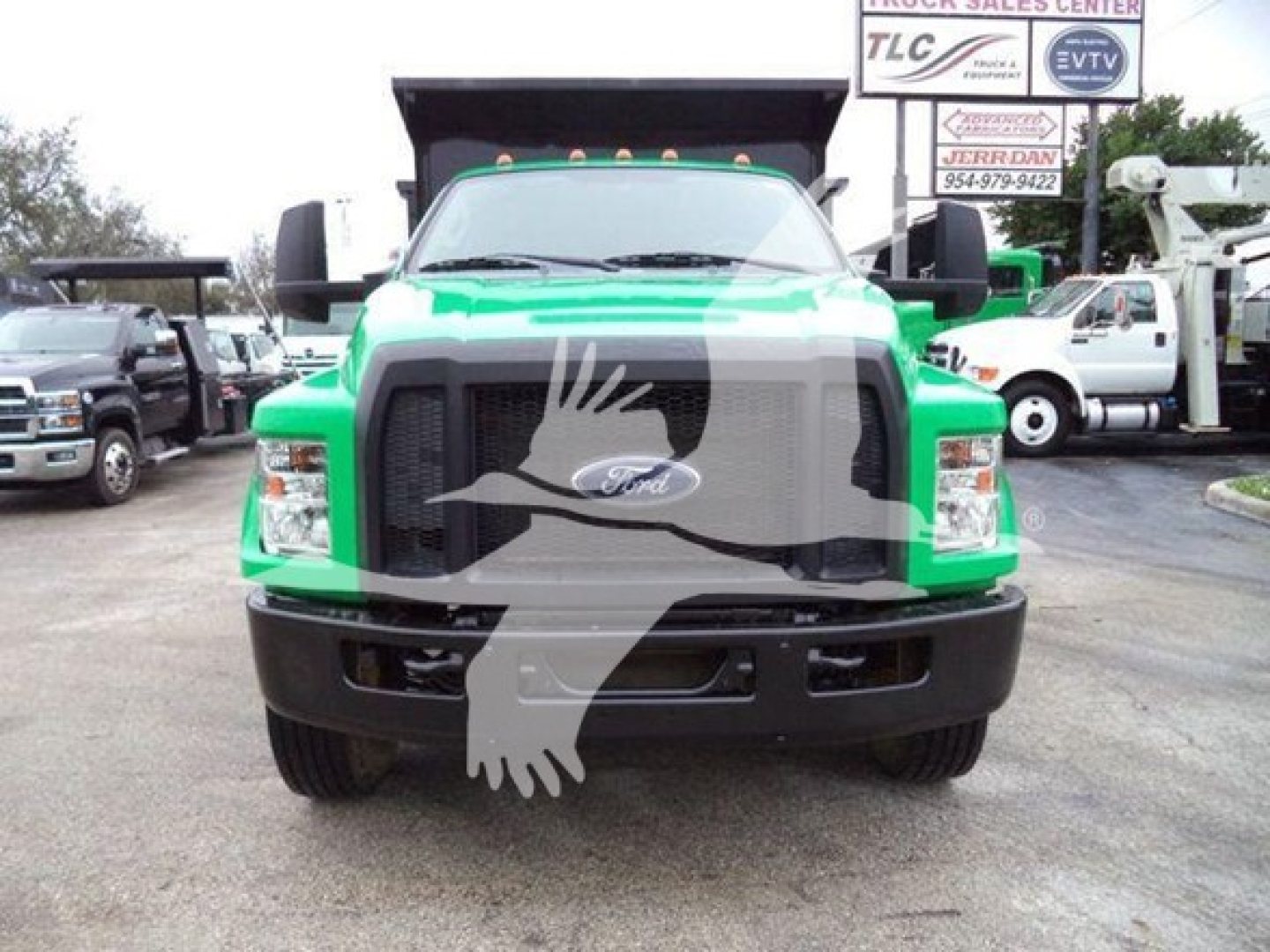 Ford F-650 dump truck front view showing green cab, large grille, and dual mirrors.