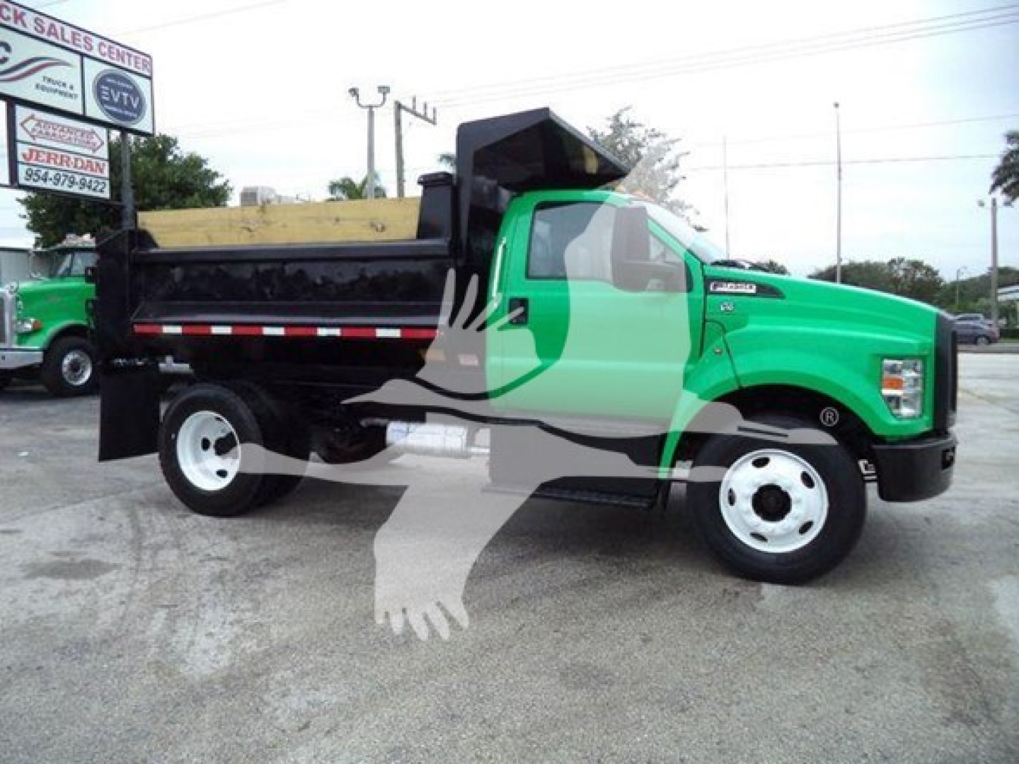 Dump truck in green and black, side view showing dump bed and wheels with Ford F-650 badge