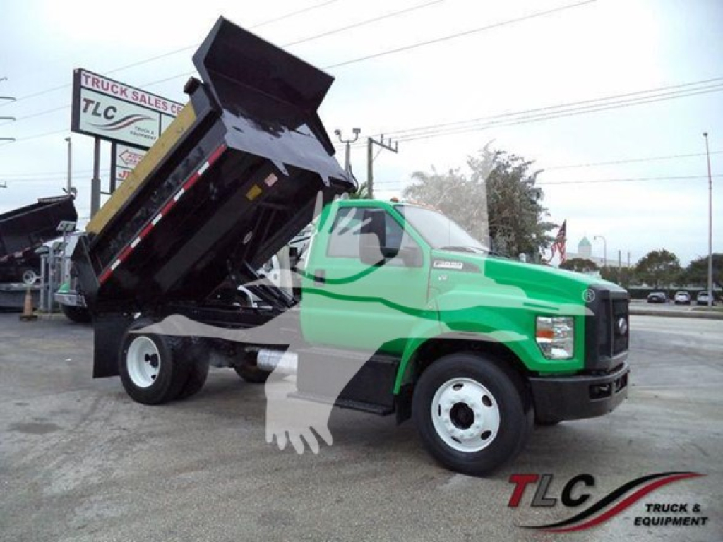 2017 Ford F650 dump truck with green cab and raised dump bed in a dealership lot showing TLC Truck Sales branding.