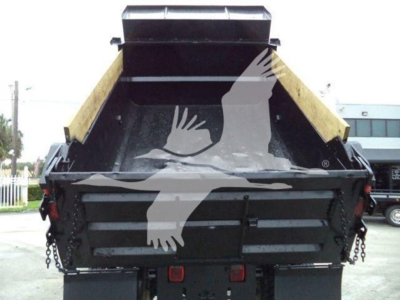 Dump truck bed of a 2017 Ford F650 with black metal sides and yellow dump bed sides; chain hookups visible at rear and hydraulic mechanism in center.