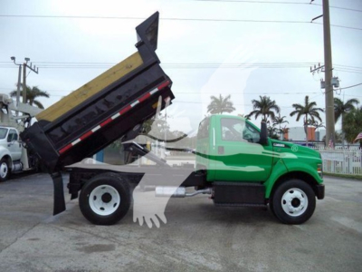 2017 Ford F650 dump truck in green showing raised dumping bed with hydraulic cylinder visible.
