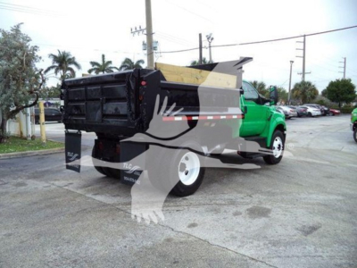 Truck bed of a 2017 Ford F650 dump truck showing rear and side with green cab and large black dump body.