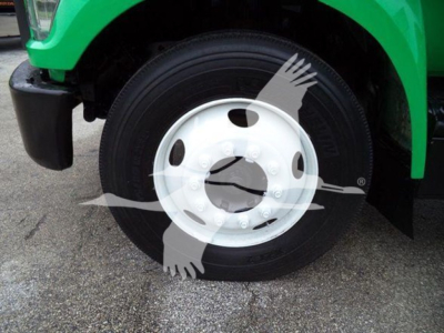 Ford F650 front wheel showing steel wheel and tire under green fender.