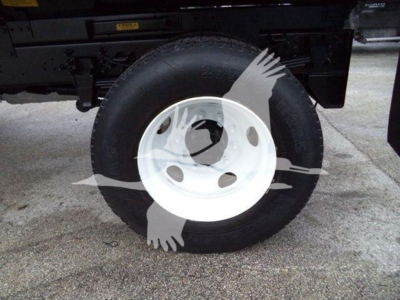 Wheel and tire assembly of a 2017 Ford F650 Sd dump truck showing white steel wheel with black tire and part of truck frame