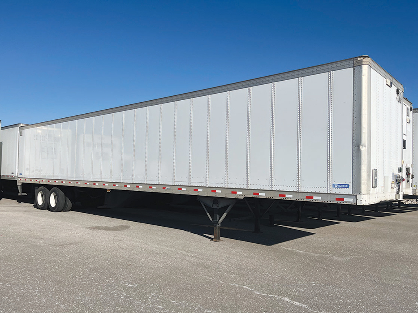 Trailer undercarriage and side view of a 2019 Stoughton Z-Plate dry van trailer with white exterior and tandem wheels.