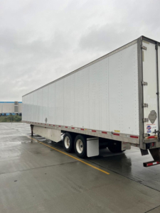 Utility van trailer showing a long white semi-trailer with tandem axles