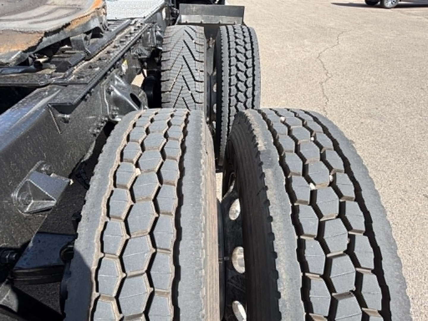 Kenworth T680 chassis showing dual rear axles with hex-pattern tread on tires and visible frame rails.