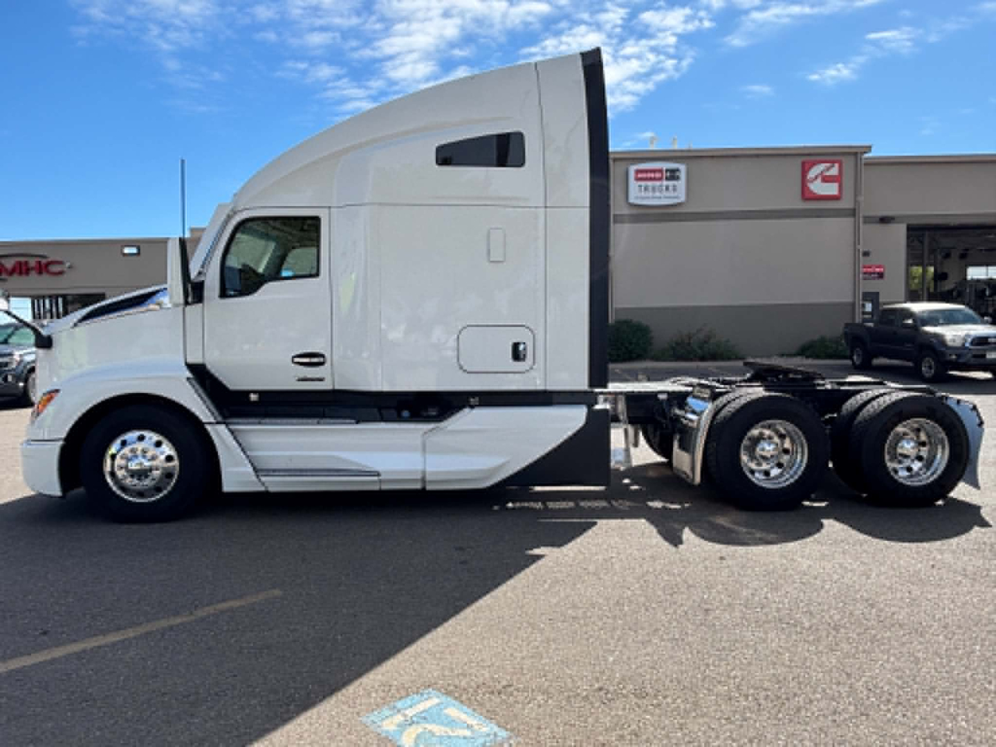 Kenworth T680 conventional sleeper truck side view showing cab and chassis with white paint and dual rear axles.