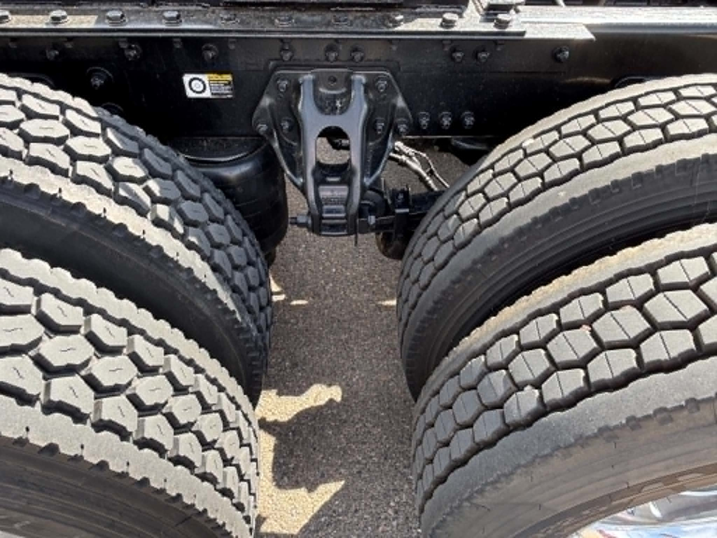 Truck rear view showing tandem axle suspension and leaf spring components of a Kenworth T680.