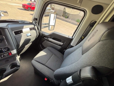 Vehicle cab interior of a 2023 Kenworth T680 showing front passenger seat and dashboard area.
