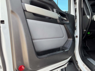 Kenworth T680 door panel view in cab showing light gray leather and black trim.