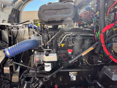 Kenworth T680 engine bay showing PACCAR three-stage diesel engine with hoses, wiring, and filters visible.