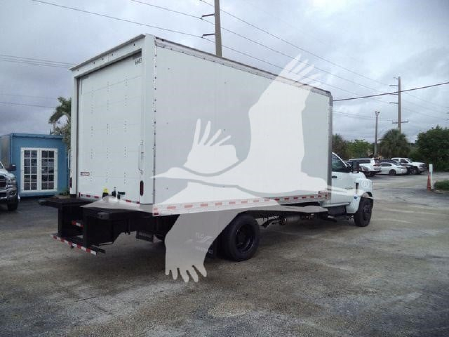 Box truck rear and side view showing cargo box with white exterior and dual rear wheels on a Chevy Silverado 6500HD chassis. Visible text includes stock number 6500BOXFM and generic box truck features.