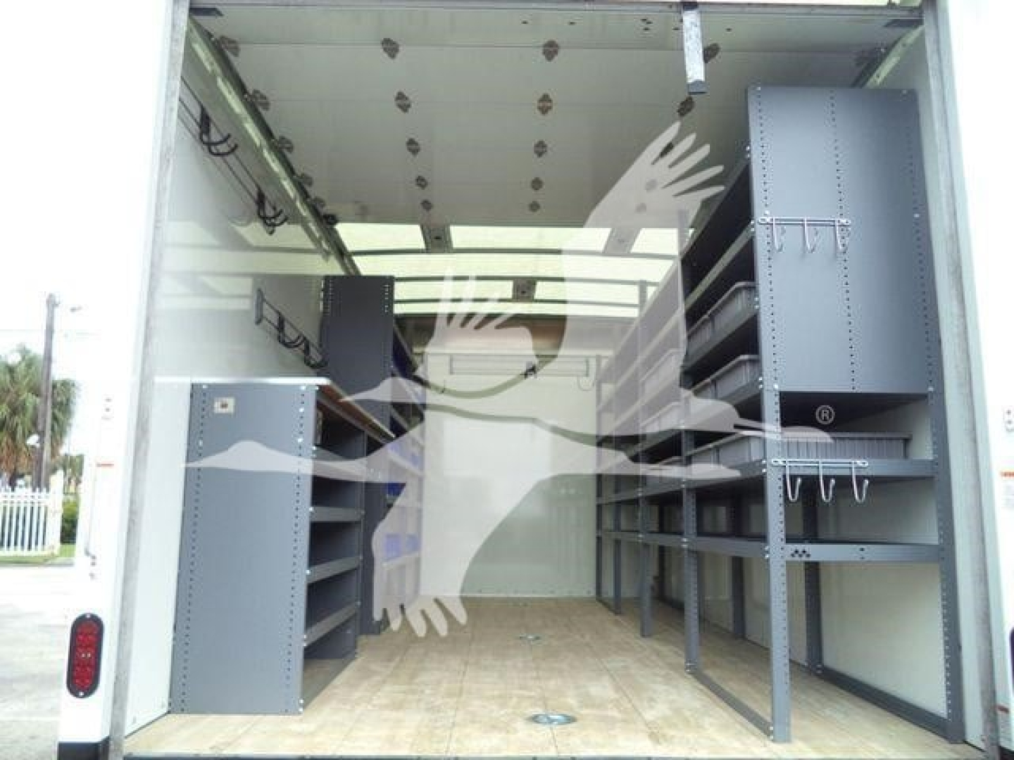 Truck cargo area showing built-in shelving and storage cabinets on both sides inside a enclosed box truck.