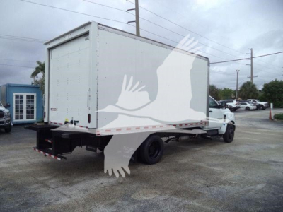 Box truck rear and side view showing cargo box with white exterior and dual rear wheels on a Chevy Silverado 6500HD chassis. Visible text includes stock number 6500BOXFM and generic box truck features.