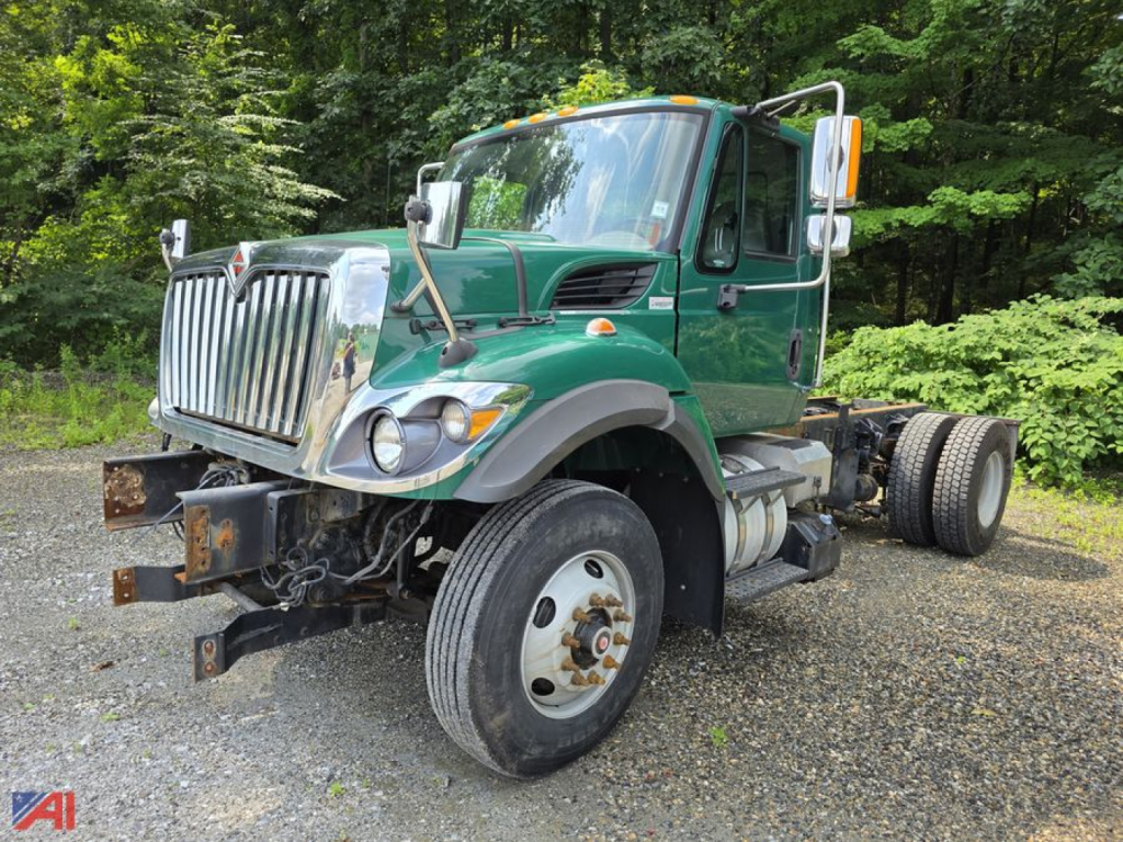 Green 2017 International WorkStar 7500 cab and chassis truck, front view, with dual rear wheels and large chrome grille, outdoor gravel lot.
