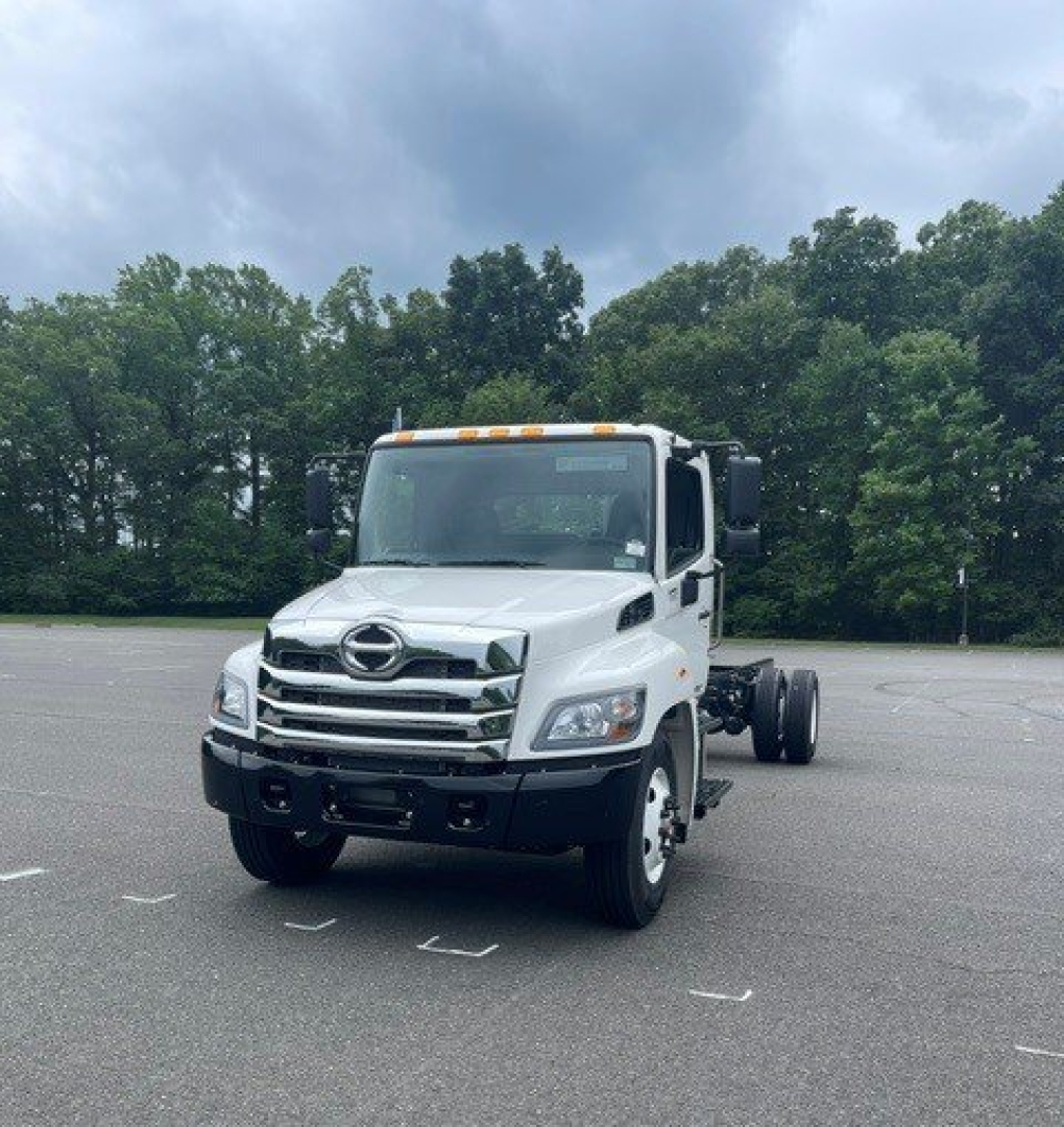 Front-left view of a white 2027 Hino L7 cab chassis truck showing grille, headlights, and side mirrors.