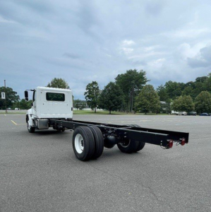 Chassis cab truck on lot showing a long frame with wheel axles and cab, no bed installed.