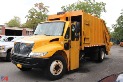 International DuraStar 4300 refuse truck body in service view showing bright yellow cab and rear waste compactor unit.