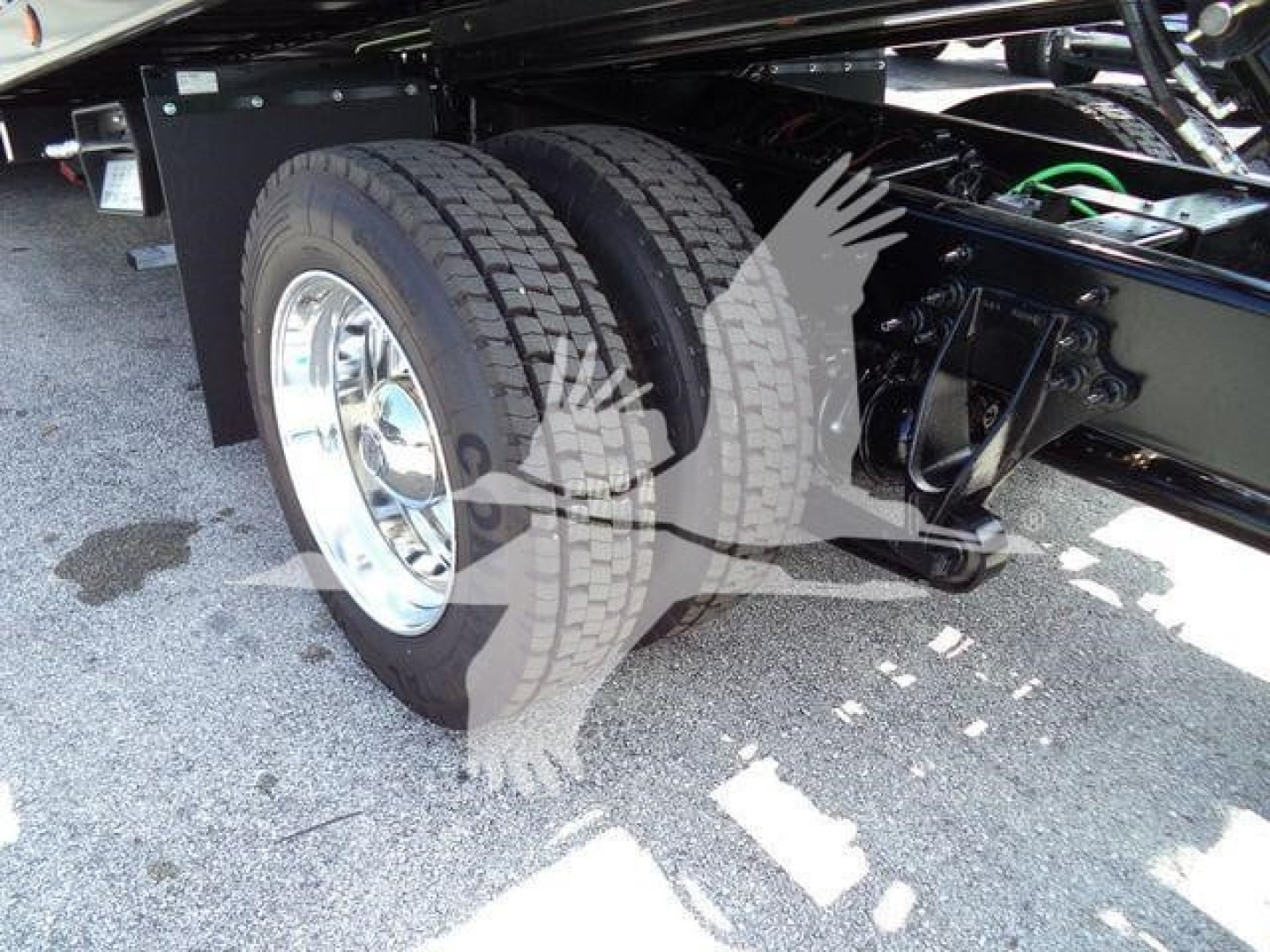 Truck rear dual axle with chrome wheel and suspension components visible underframe.