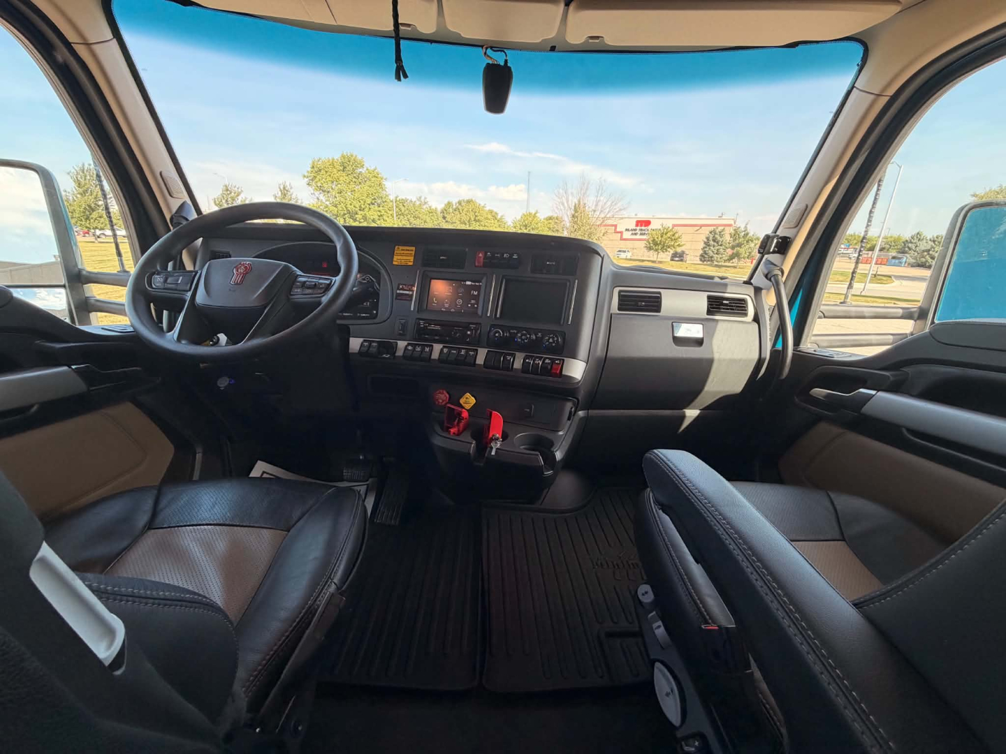 Kenworth T680 truck cab interior showing steering wheel, dashboard, and center console with controls and digital displays.