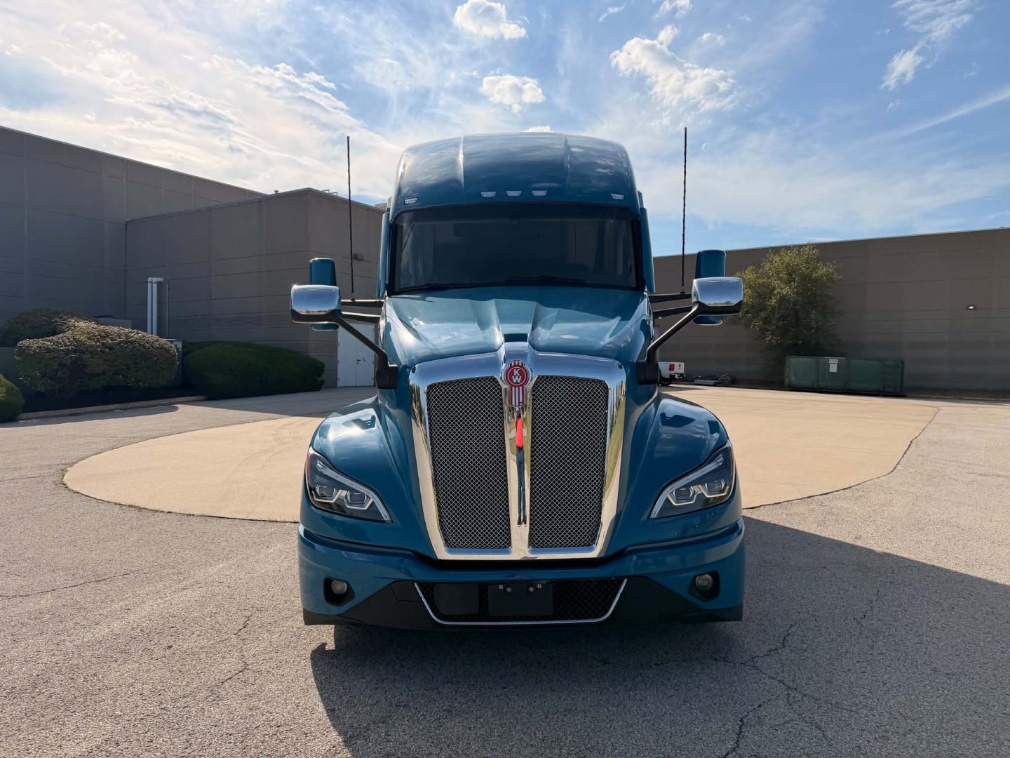Kenworth T680 front view showing bold grille and chrome bumper with blue paint.
