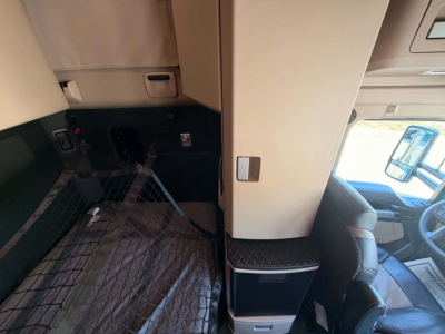 Kenworth T680 cab interior with driver seat and dashboard visible, floor mat and step area in view.