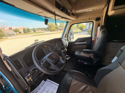 Kenworth T680 truck cab interior showing steering wheel, dashboard, driver seat, and passenger seat. Visible text includes none specific; image focuses on cabin area.