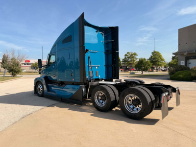 Kenworth T680 6x4 tractor in blue with sleeper, side view showing cab and rear wheels.