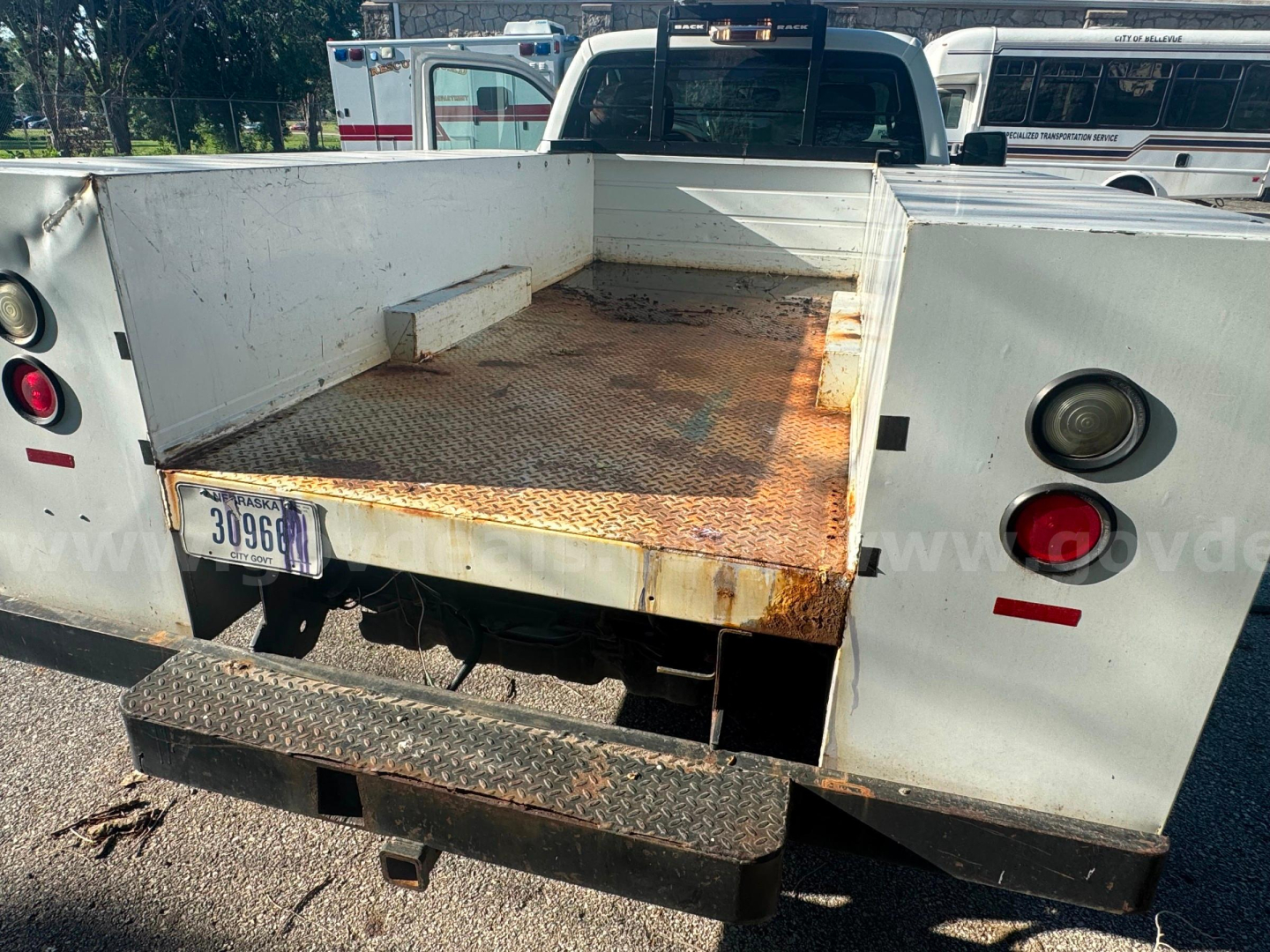 Ford F-350 service bed showing cargo area with rusted bed floor and rear bumper step.