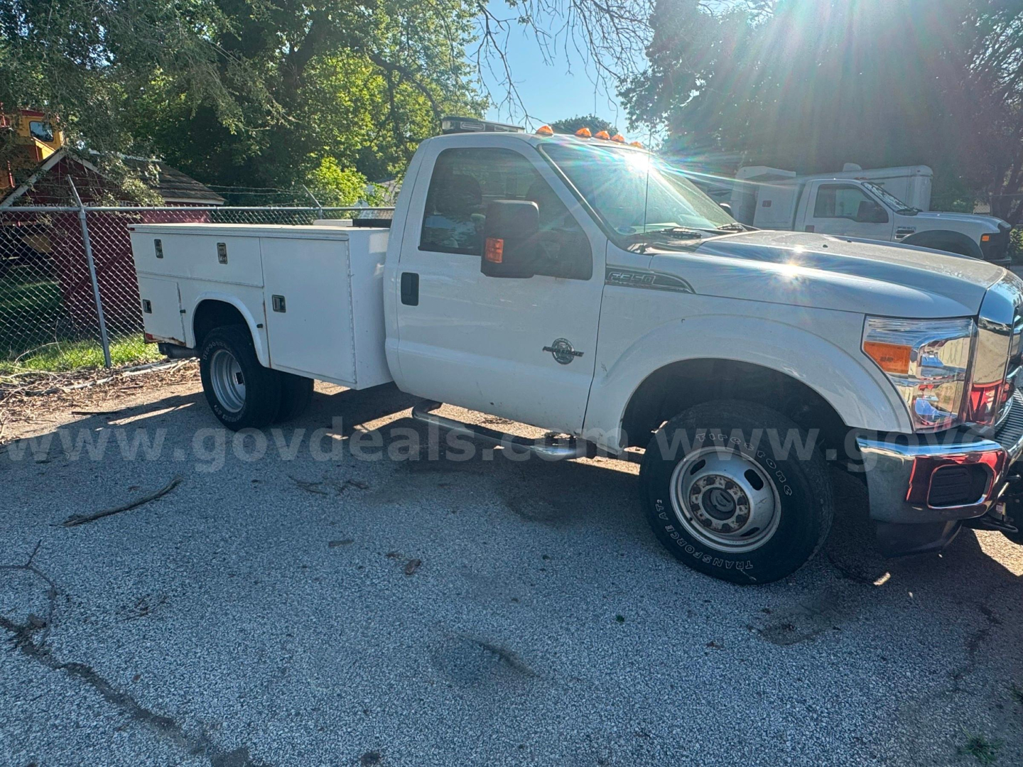 White Ford F-350 service utility truck in side view with service bed, chrome front bumper, and dual rear wheels. Visible markings include a Ford emblem and utility compartments along the bed.