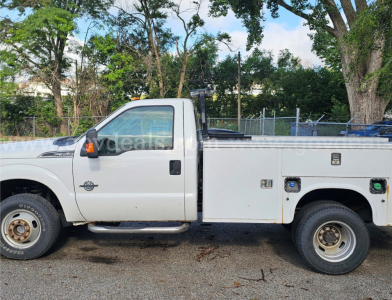 Ford F-350 utility pickup side view showing service body with compartments and rear wheel; cab and side mirror visible.