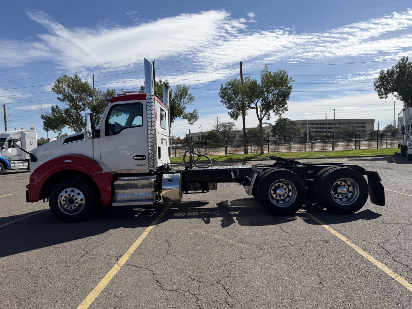 Kenworth T880 daycab tractor side view showing chassis and triple rear axles.