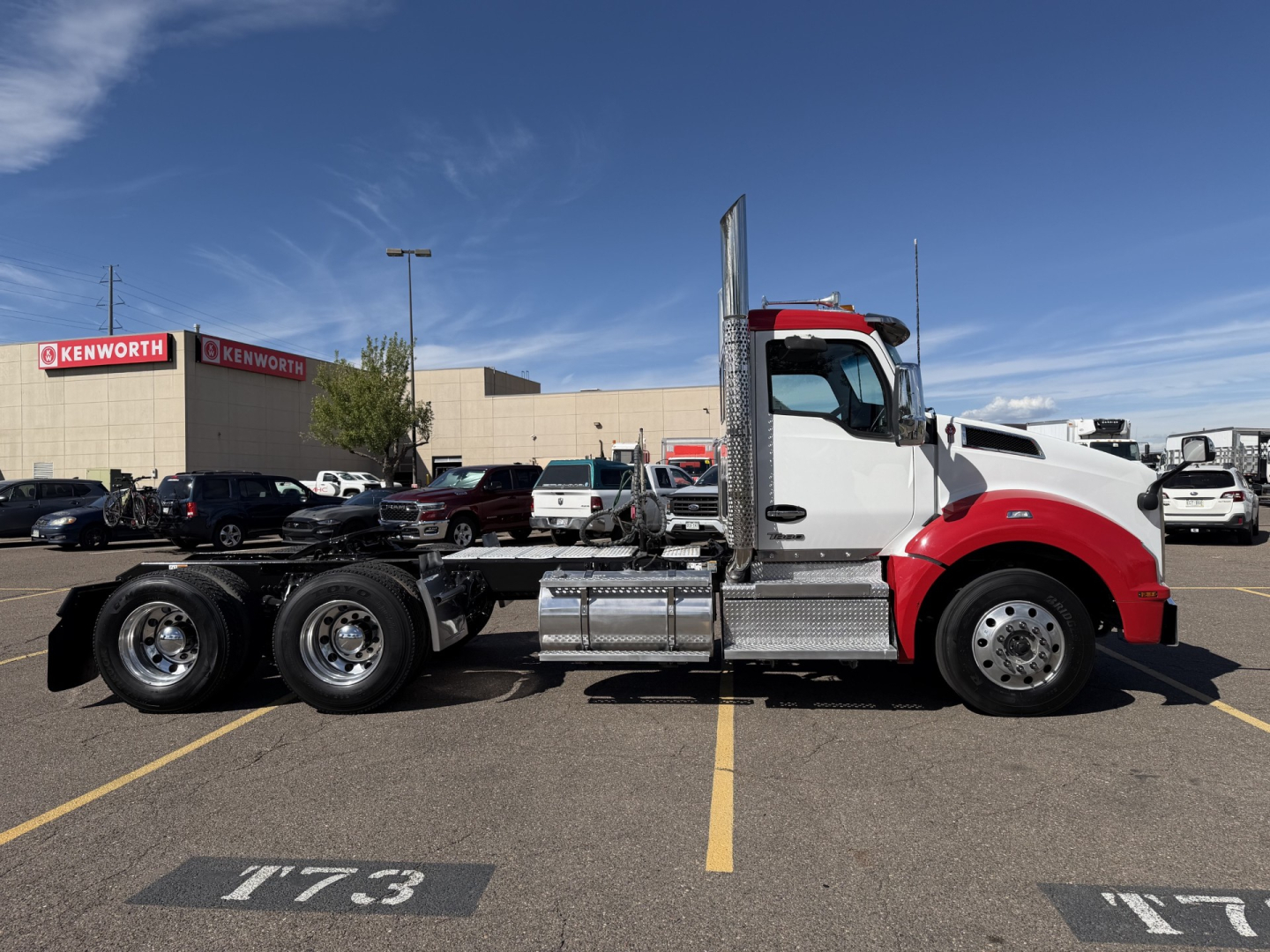 Kenworth T880 conventional daycab truck side view showing cab, fuel tanks, air tanks, and chrome steps; no visible text on the truck panels.