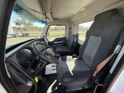 Kenworth T880 truck cab interior showing driver seat and passenger seat, steering wheel, dashboard, and large side window.