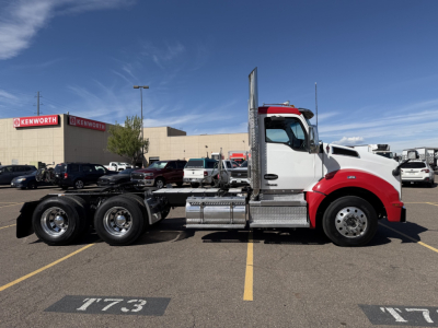 Kenworth T880 conventional daycab truck side view showing cab, fuel tanks, air tanks, and chrome steps; no visible text on the truck panels.
