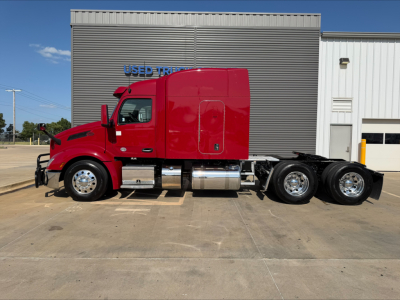 Peterbilt 579 tractor in red, side view, with dual rear axles, chrome fuel tanks, and cab accessories.