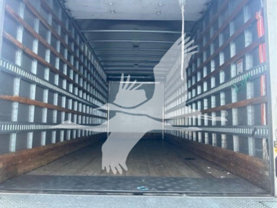 Interior view of a used 2023 Hino L6 box truck cargo area with wooden floor and metal side rails.