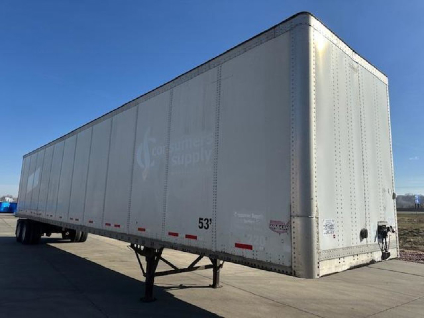 Semi trailer van with silver exterior showing 53' length markings and rear hitch. Faint logos and text on side.