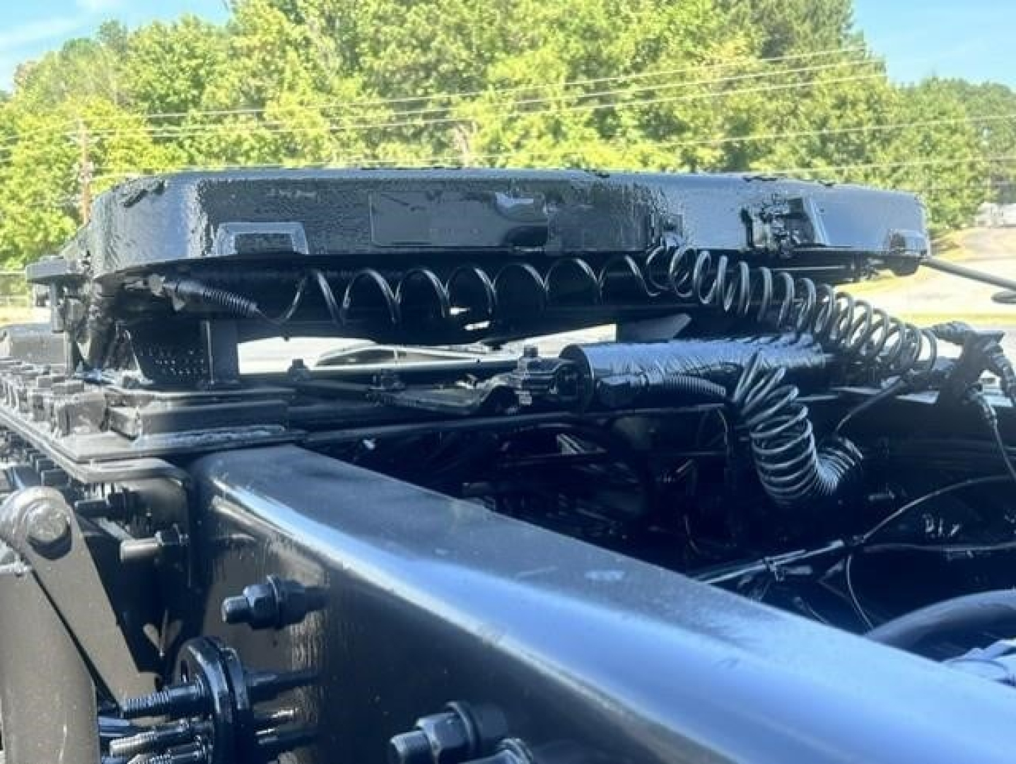 Freightliner Cascadia truck chassis view showing air lines, coil springs, and mounting hardware from the cab area.