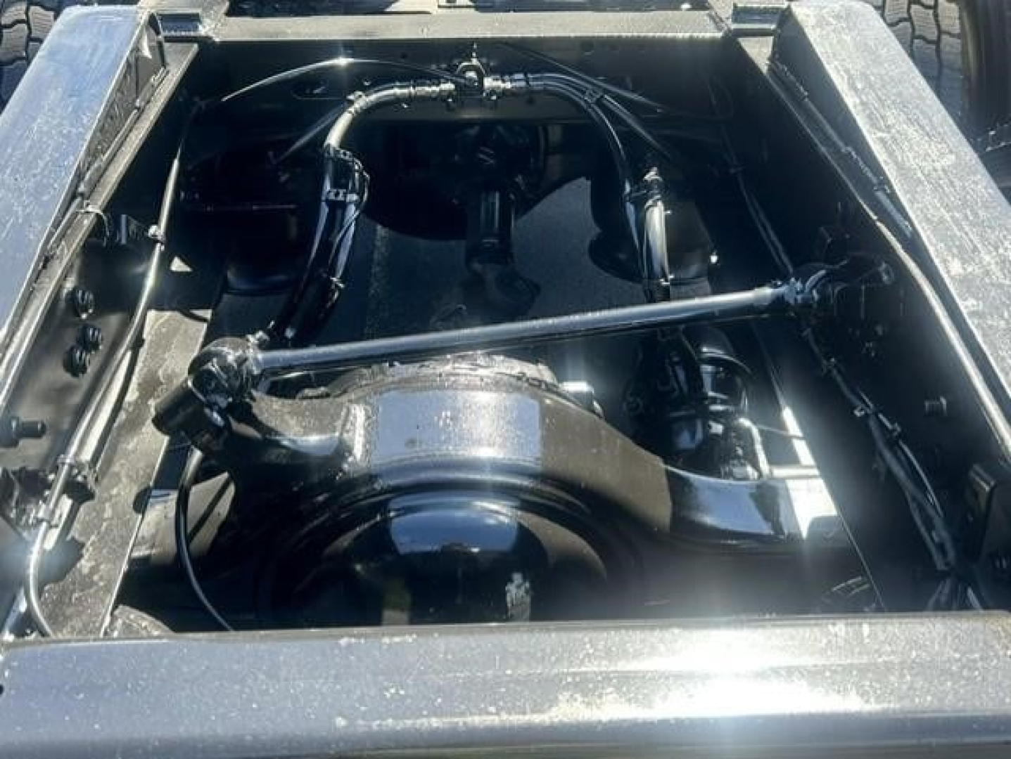 Freightliner Cascadia engine bay showing H13 turbo and wiring harnesses. Visible components include air intake, hoses, and metal framing.